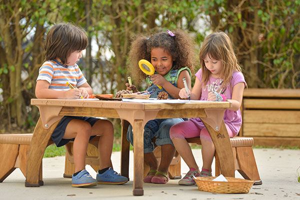 children examining nature items with magnifying glass