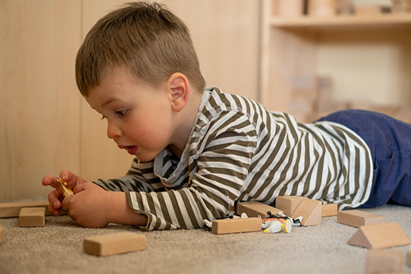 young child playing with mini Unit blocks