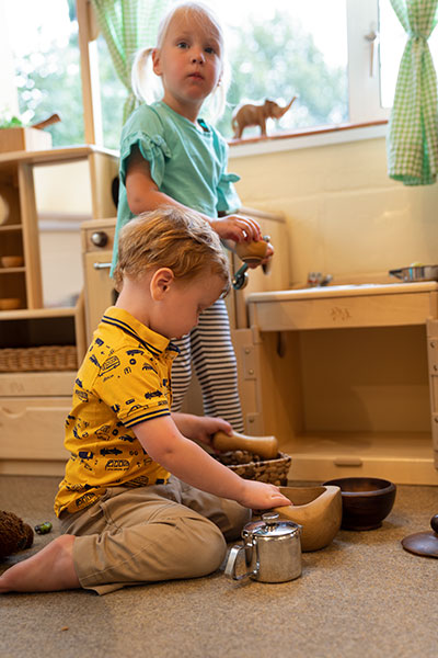 two children playing together with open ended household materials