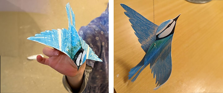 the finished paper bird, once in the hand of a child, once on a string