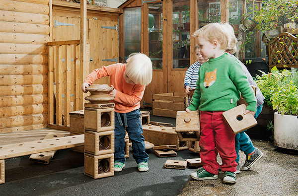 two-year-olds engaged in active play stacking outlast blocks
