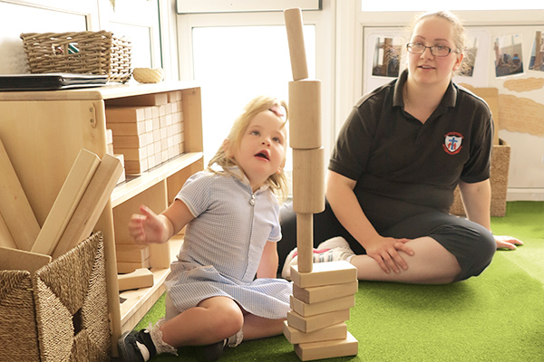 girl with block tower tipping