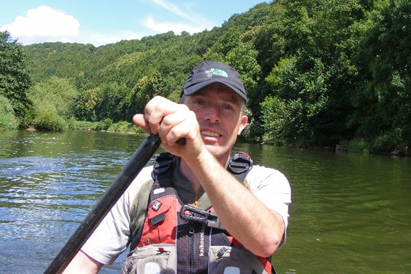 Daniel Spry canoeing down a river