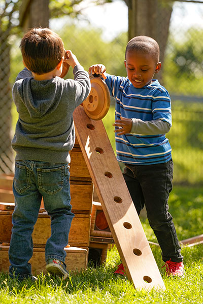 Two boys playing with Outlast blocks and planks