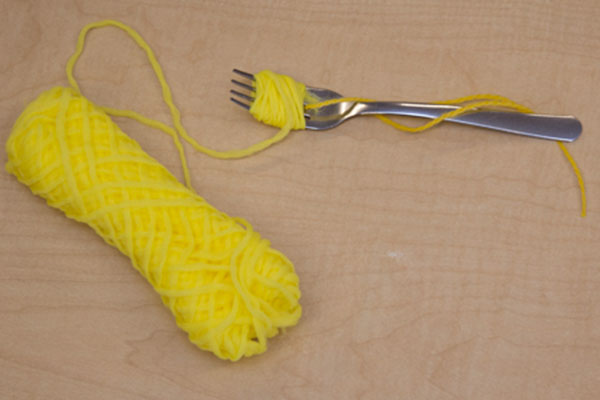 fork with yarn wrapped around tines