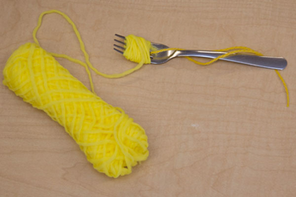 fork with yarn wrapped around tines