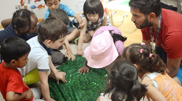 a group of children discussing something with the teacher