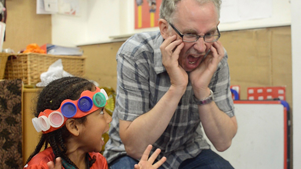 a child and teacher acting a silly song together