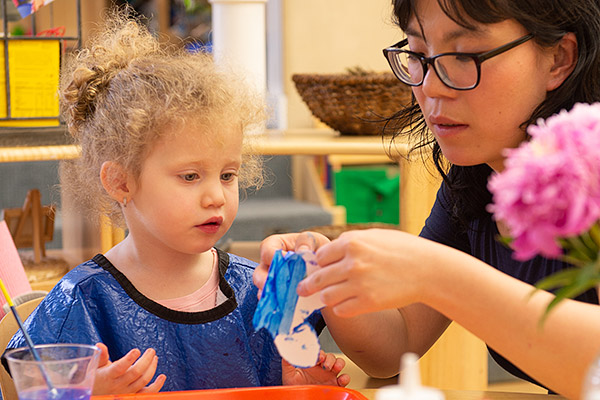 Teacher helping child with art project