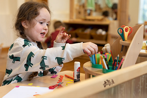 Child selecting pen from an art equipment organizer