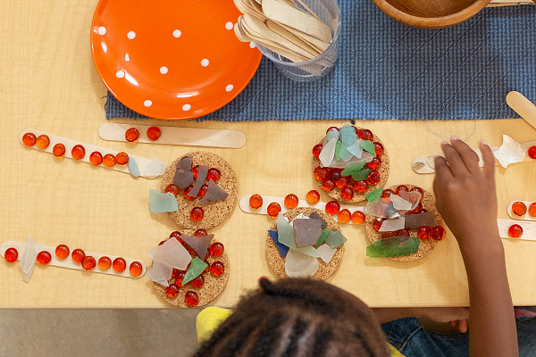 Child arranging art material on table