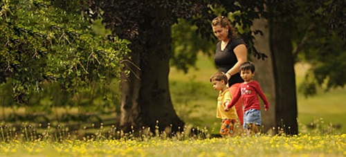 Mother with two children going on a walk outside in nature