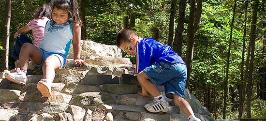 children climbing a boulder