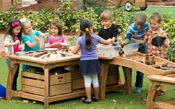 group of nursery aged children egrossed in water play with the outlast cascade