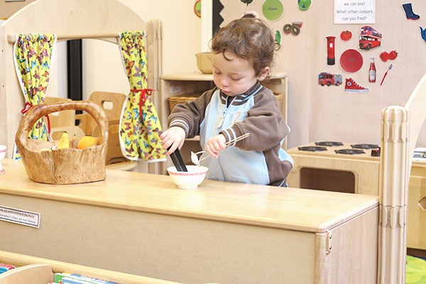 little boy with role playing with cooking pot