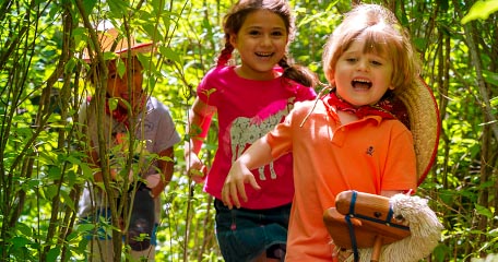 Children running through a forest.