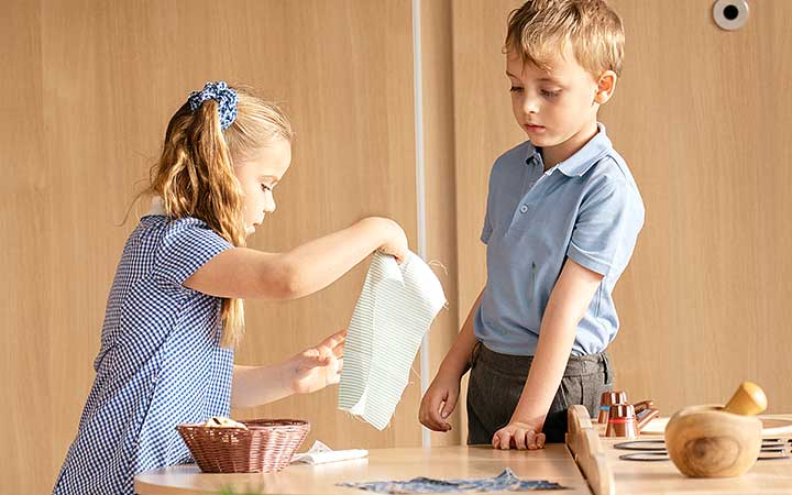 A boy and a girl discussing their play in the role play area