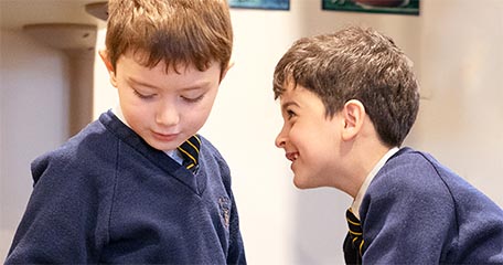 boy leaning down to talk with another boy