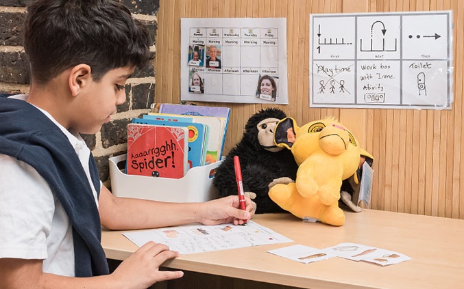 boy sitting at a desk writing