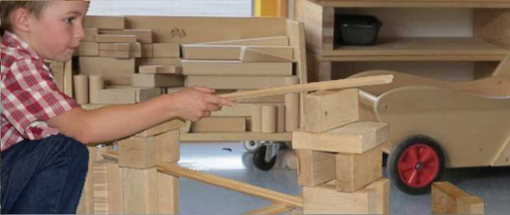 A six year old boy is experimenting with ramps and unit blocks