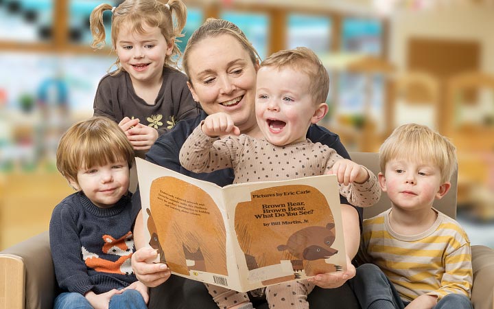 Children and teacher looking at a book