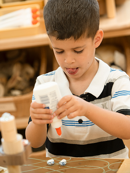 A boy is concentrating on an art project