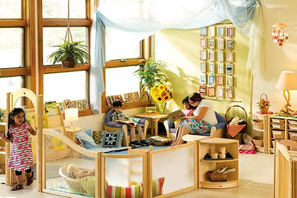 children and teacher share books in the book corner