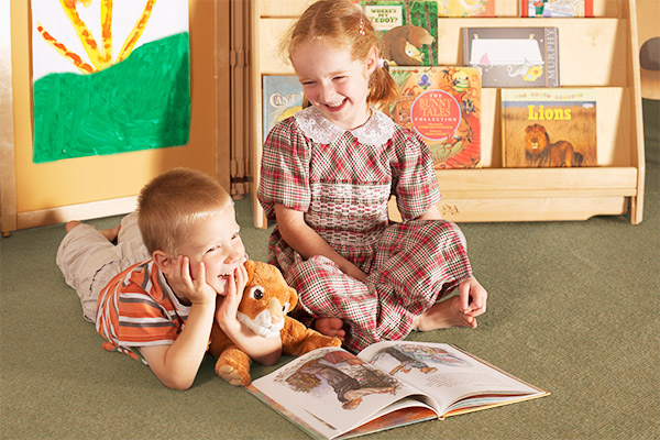 two children enjoy a book together