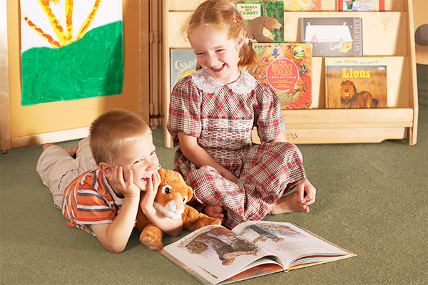 two children enjoy a book together