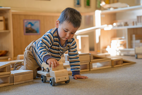 young boy playing with blocks and a toy truck