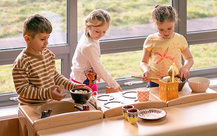 Reception aged children playing with open ended materials in the role play corner