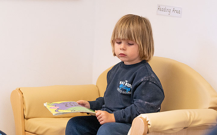 boy sitting by himself on a sofa and looking weary