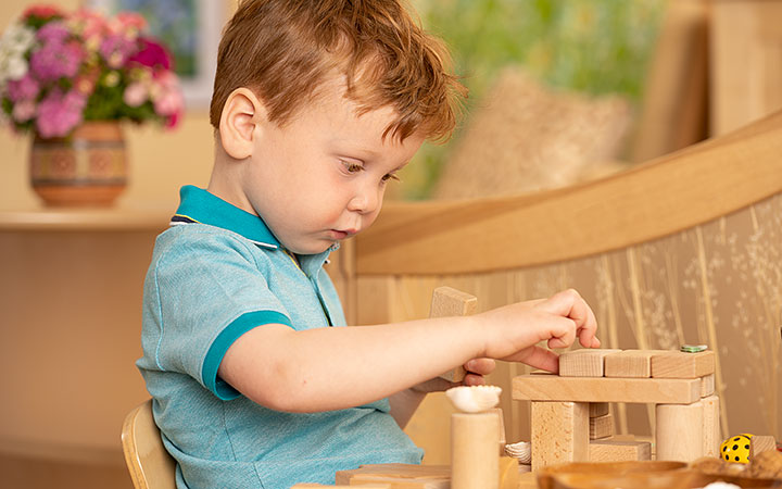 small boy playing with wooden blocks