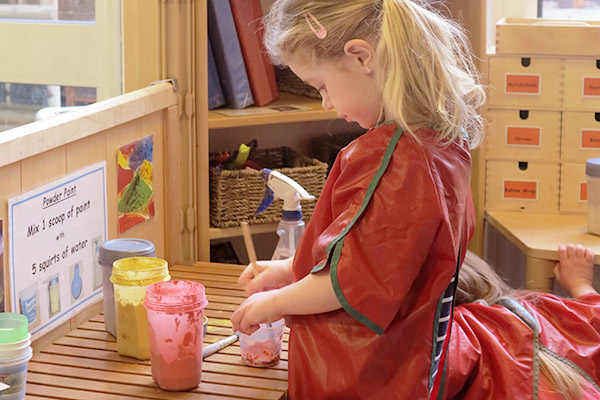 girl painting with apron on