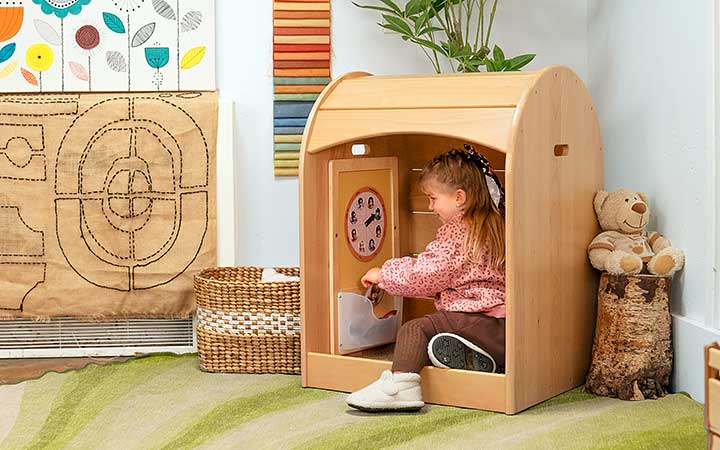 A child in a cosy space engaged in play.