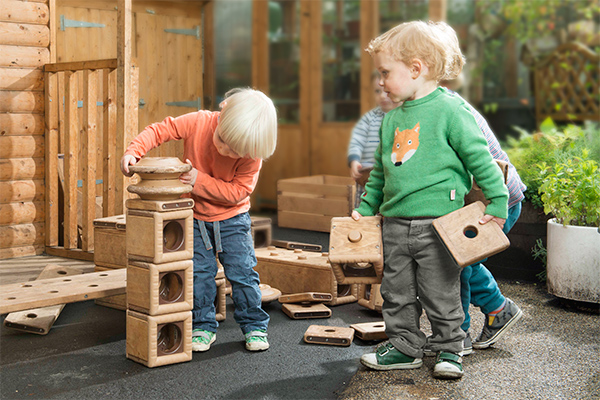 a few children stacking and carrying Outlast blocks