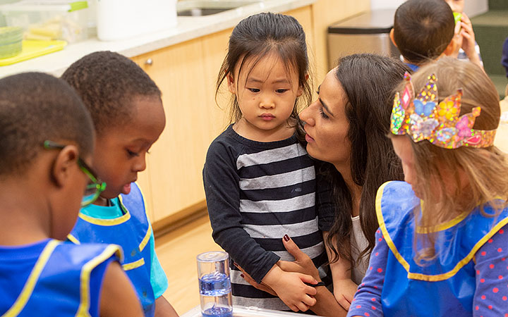 Nursery teacher is helping a young child to express her feelings