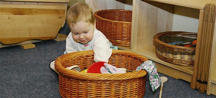 Baby playing with items in a treasure basket