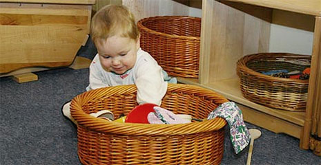 Baby playing with items in a treasure basket