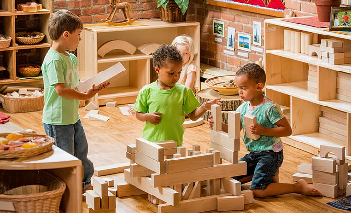 Three children playing in a block corner