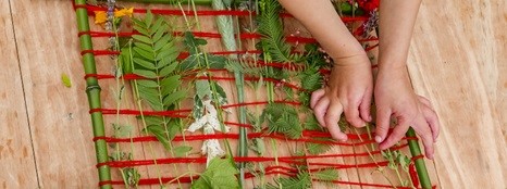 A child’s hand weaving natural materials