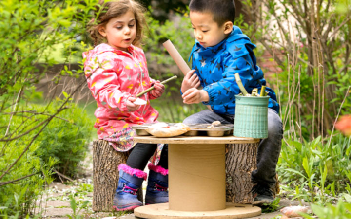 A boy and girl in a DIY outdoor homecorner
