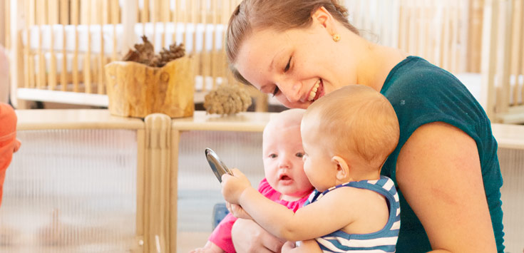 A practitioner holding two babies