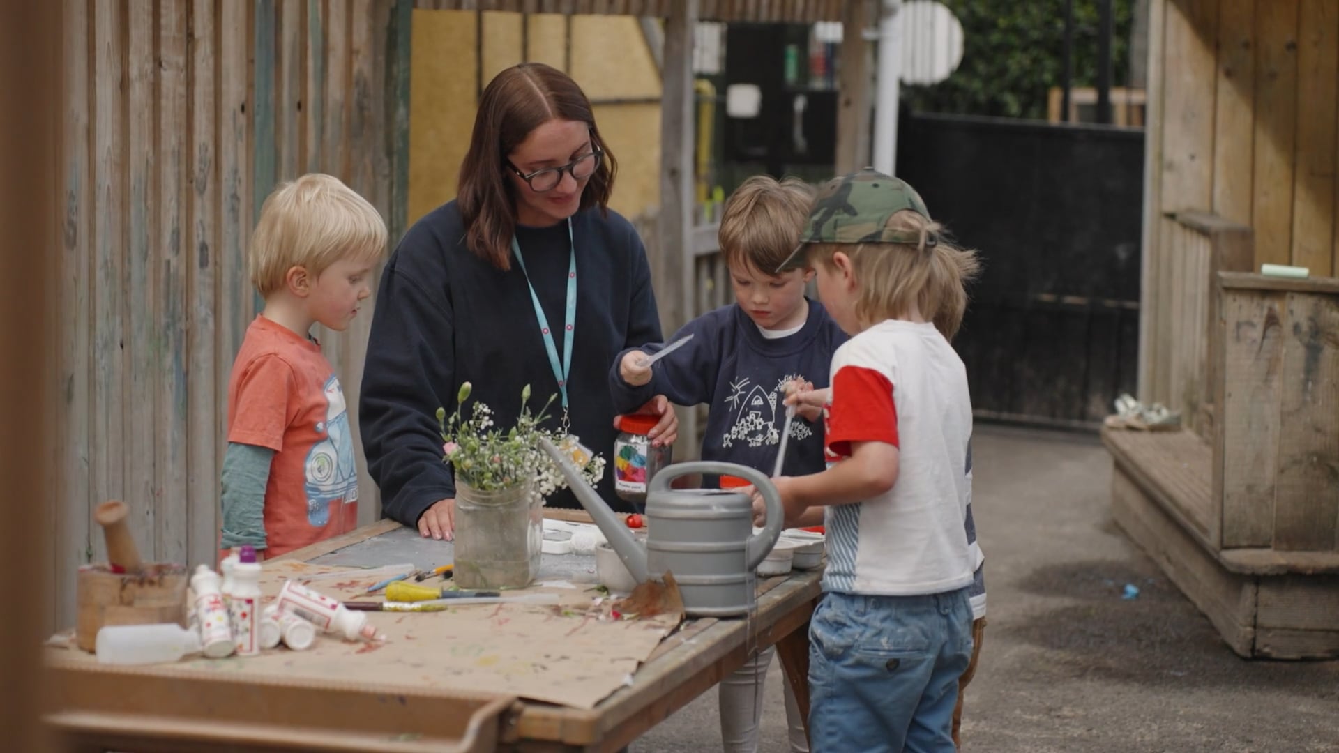 Teacher and children with art outside