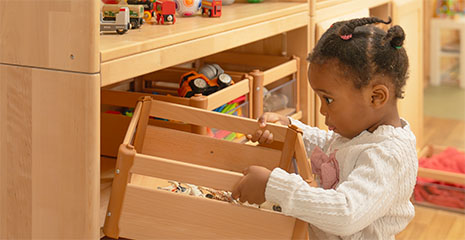 Child putting a carry crate on a shelf