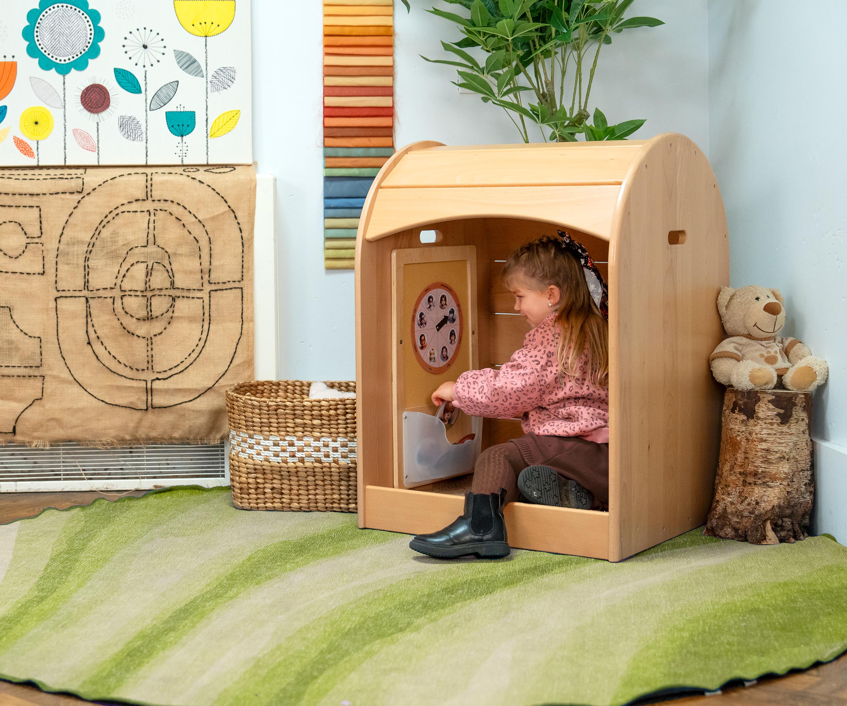 toddler girl sitting in a Nest nook calm corner and placing cards on the Felt Board