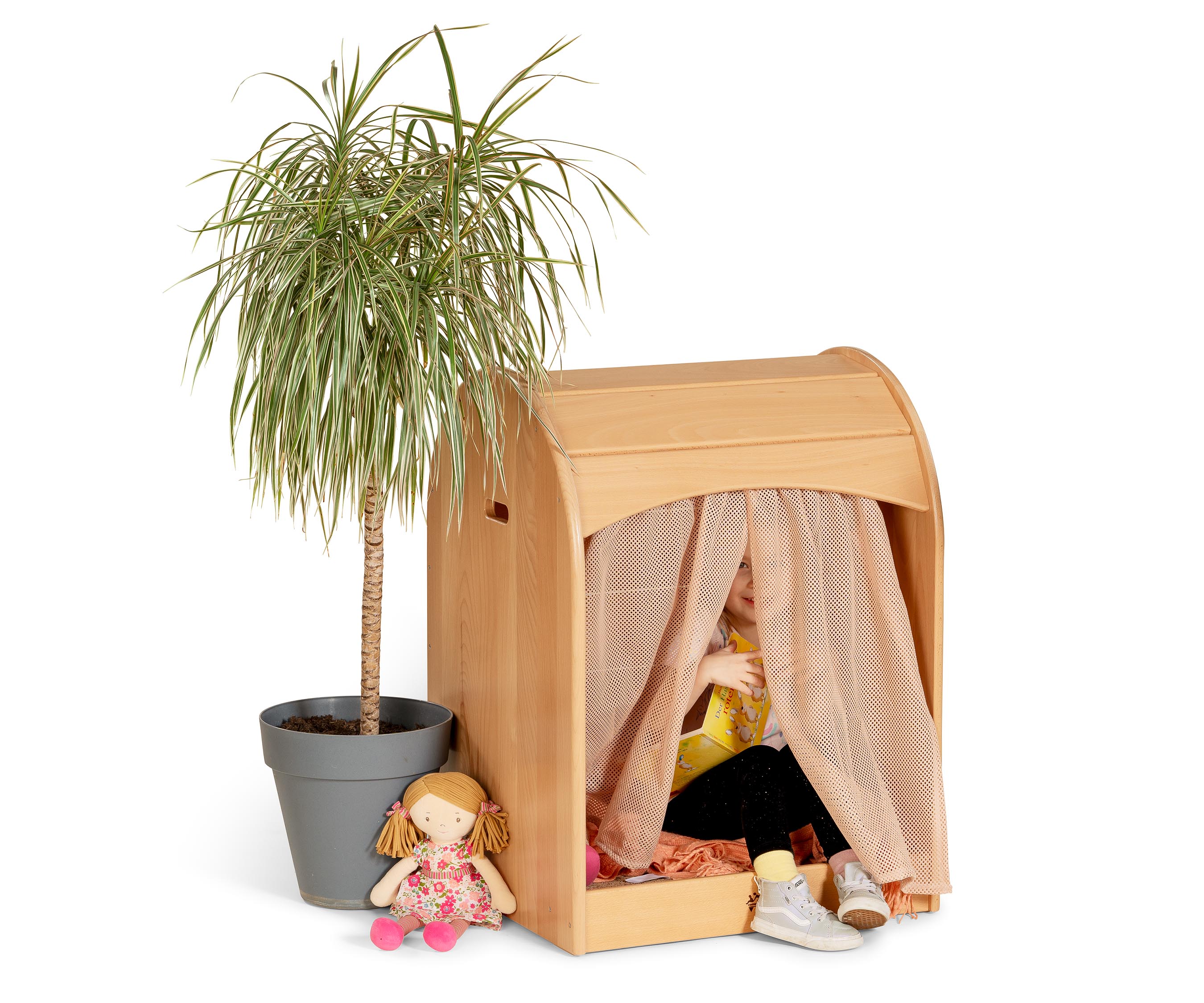 A Nest Nook with a palm tree placed near it and a child sitting inside peeking out of the curtain