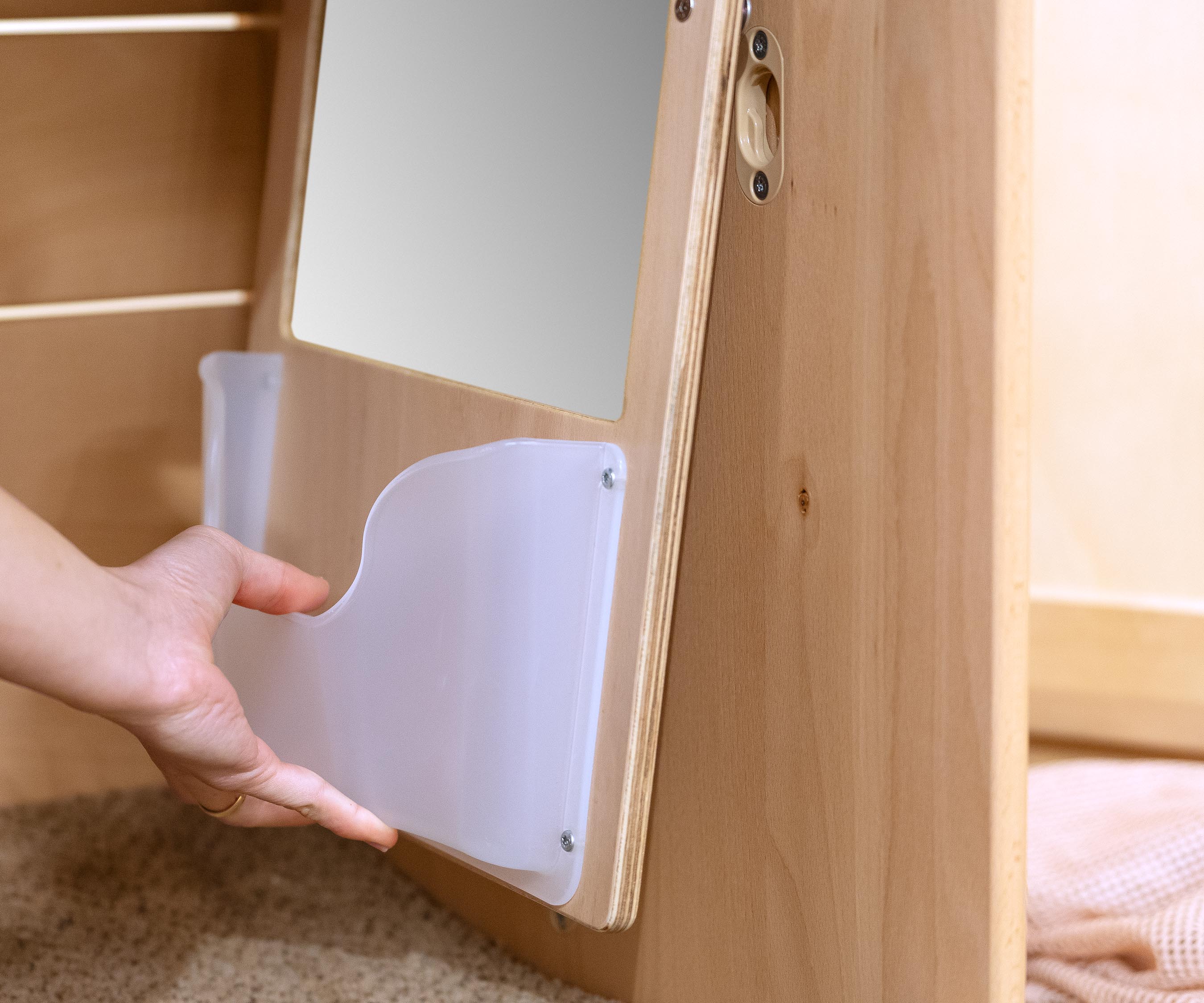 A staff member placing a Mirror Board with Pocket into a Nest Nook.