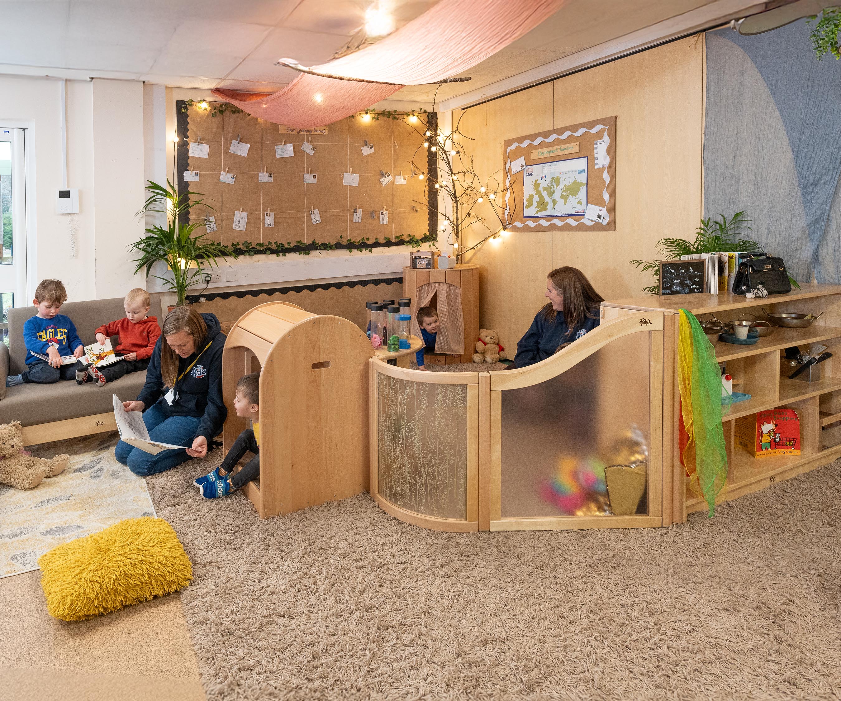A nursery calm corner set up with a Hollow Nook, Nest Nook, and other natural wood furniture