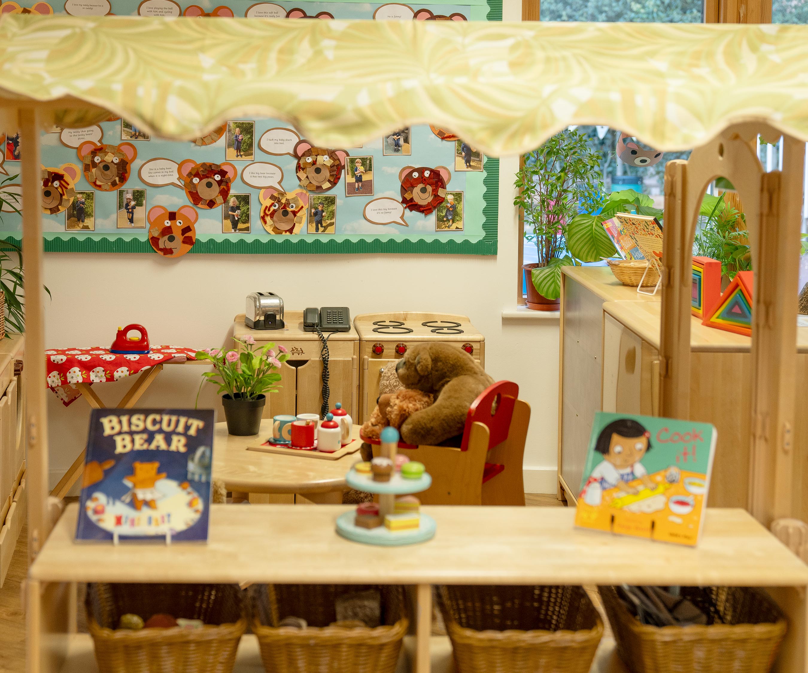 Solid wood shelf in a role play corner set up with play materials for children.